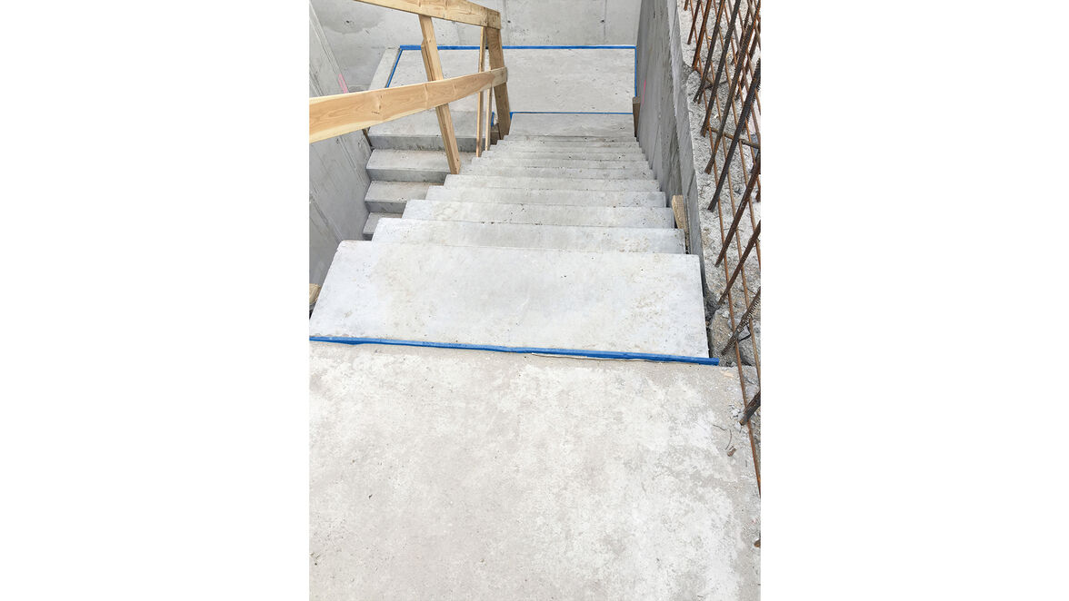 System Tronsole niebieską linią oddziela akustycznie schody od ścian i spocznika, dzięki czemu skutecznie wytłumia dźwięki uderzeniowe na klatce schodowej. Fot. Schöck