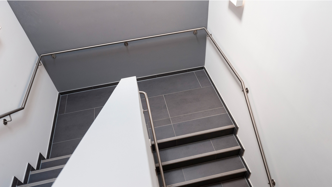 L’escalier en éléments préfabriqués dans l’extension s’enroule avec une ou deux volées autour d’une paroi dans le jour de l’escalier L’escalier en éléments préfabriqués dans l’extension s’enroule avec une ou deux volées autour d’une paroi dans le jour de l’escalier