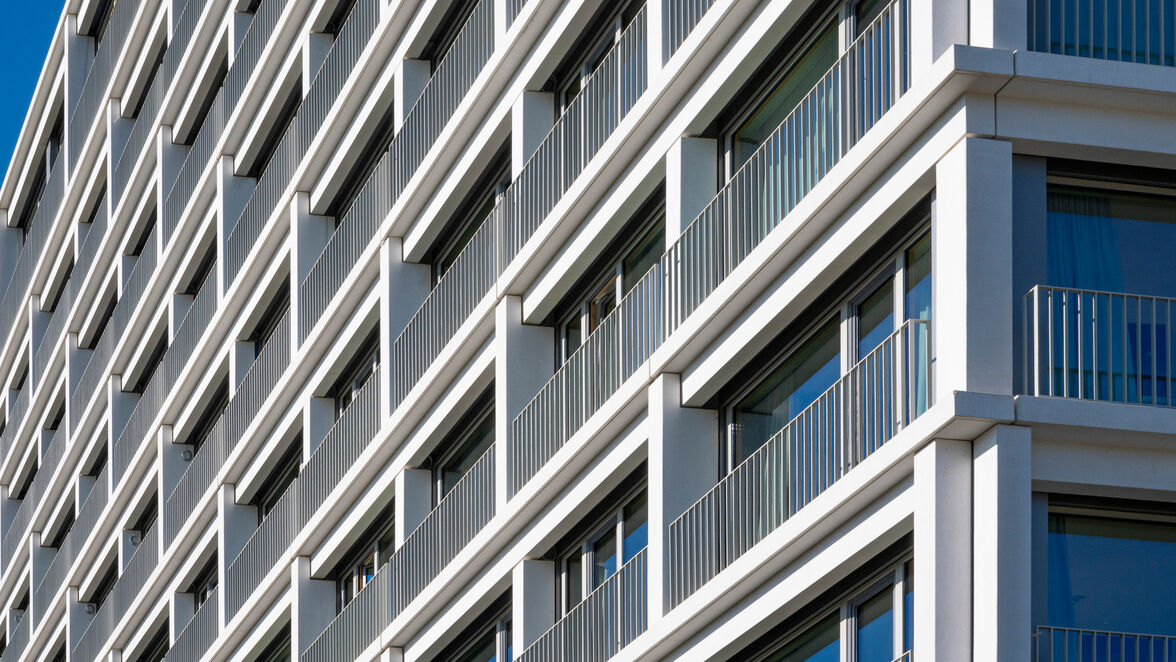 Die Gesimse aus weißen Betonfertigteilen mit einer Gesamtlänge von rund 1.000 Laufmeter sind wie Balkone geplant, frei begehbar und mit einem Geländer gesichert. 