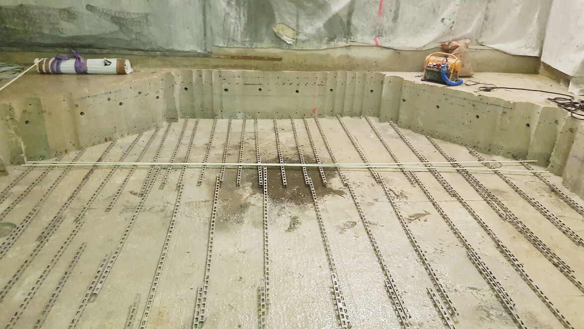 Eine oktogonale Vertiefung mit 5.400 Millimeter Durchmesser und 600 Millimeter Tiefe. Bohrungen an den Seiten nehmen die neuen Bewehrungsanker auf. 