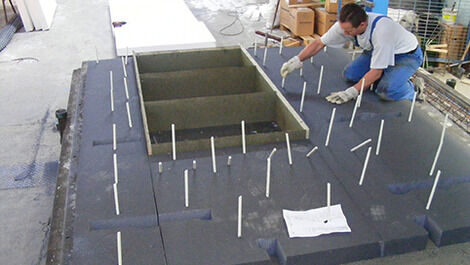 Die ComBAR Thermoanker von Schöck werden im Fertigteilwerk zunächst in der gedämmten Sichtbetonaußenschale verankert; dazu steckt man sie durch die vorgebohrten Dämmplatten, die sozusagen als Halterung dienen. (Foto: Schöck Bauteile GmbH, Abdruck honorarf