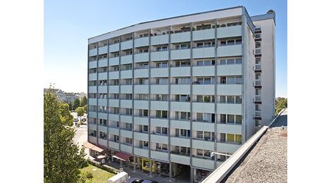 Gesamtansicht der Fassade nach der Balkonsanierung: Die neuen Freisitze können mit ihren Brüstungen aus türkisblauen Hochdruck-Schichtpressstoffplatten auch gestalterisch überzeugen.
