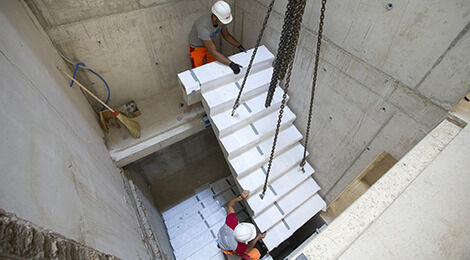 Die vorfabrizierten Treppenelemente wurden per Kran in das neu betonierte Treppenhaus eingebracht und passgenau versetzt. Foto: Schöck Bauteile AG