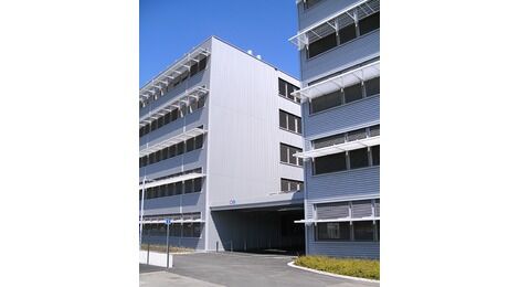 Laborgebäude 2 und 3 (links) der Viollier AG in Allschwil BL sind mit einer stützenfreien Stahlkonstruktion miteinander verbunden. Quelle: Viollier AG/Otto + Partner AG